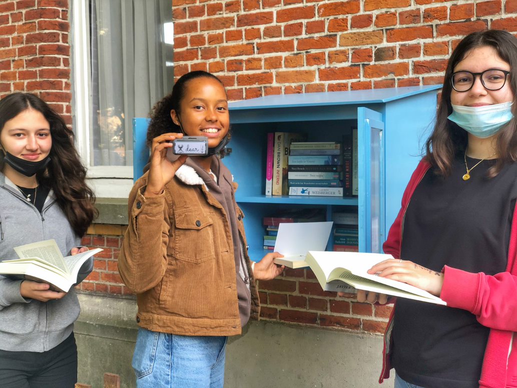 leerlingen aan één van de DEAR-boekenkastjes op onze campus